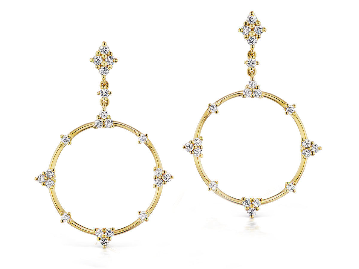 Gold earrings with circular design and diamond accents on a white background