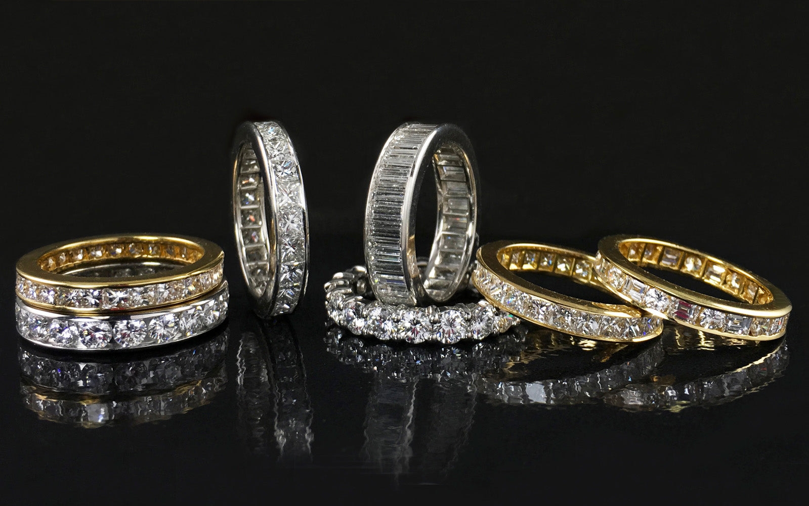 Diamond wedding bands on a black surface