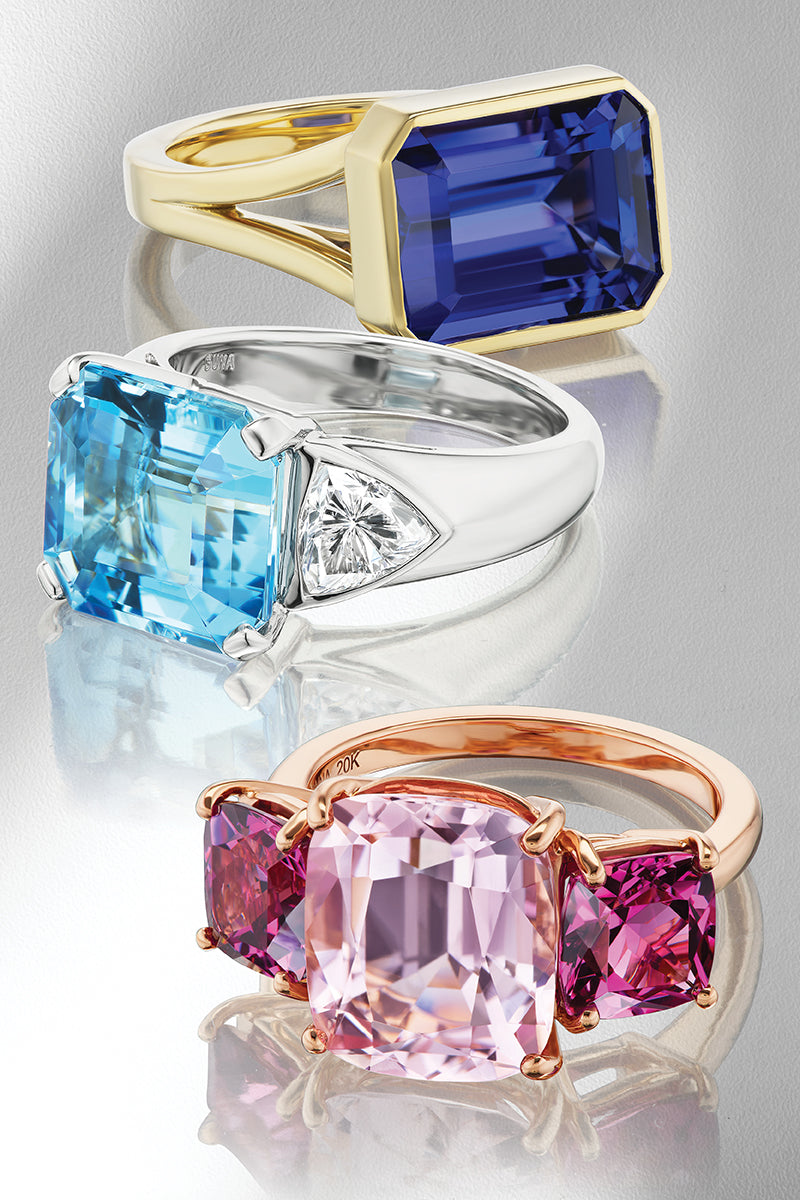 Rings with colorful gemstones on a gray background