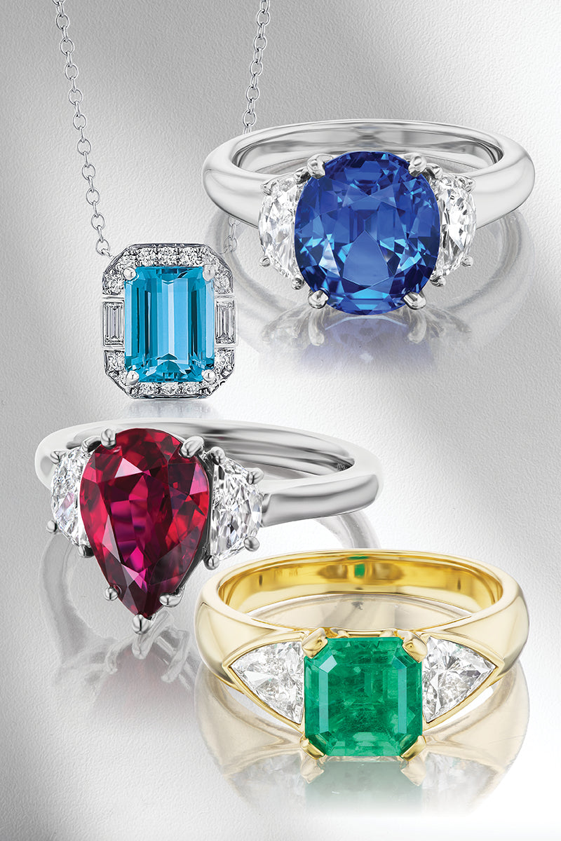 Pendant and rings with colorful gemstones on a gray background