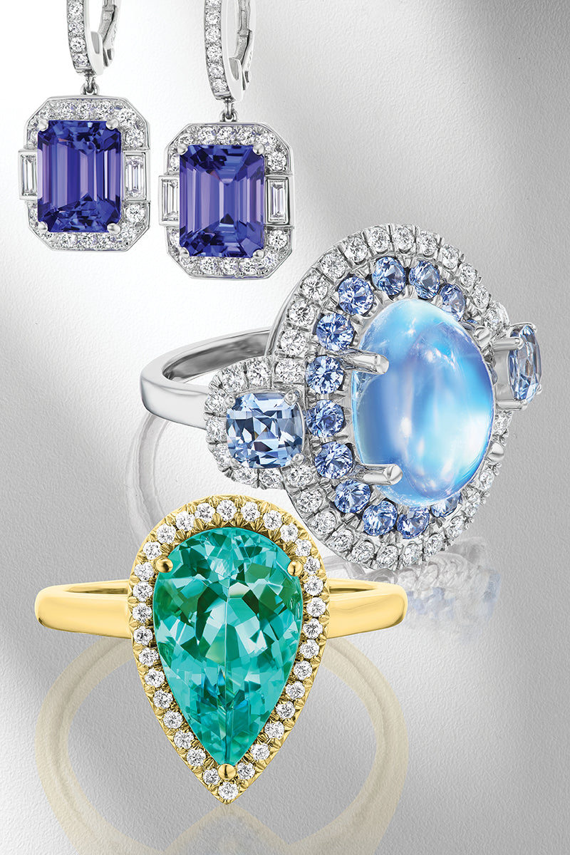 Rings and earrings with colorful gemstones on a gray background