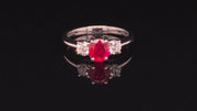 Video of rotating 18K white gold ring featuring a ruby and two round diamonds on black background