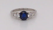 Video of rotating platinum ring with an oval sapphire with four diamonds on white background