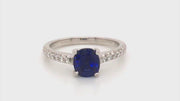 Video of rotating platinum ring featuring a sapphire with round diamonds on white background