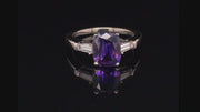 Video of rotating ring with purple gemstone and diamonds on black background