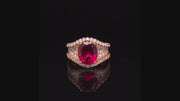 Video of rotating ring with red gemstone and diamonds on black background