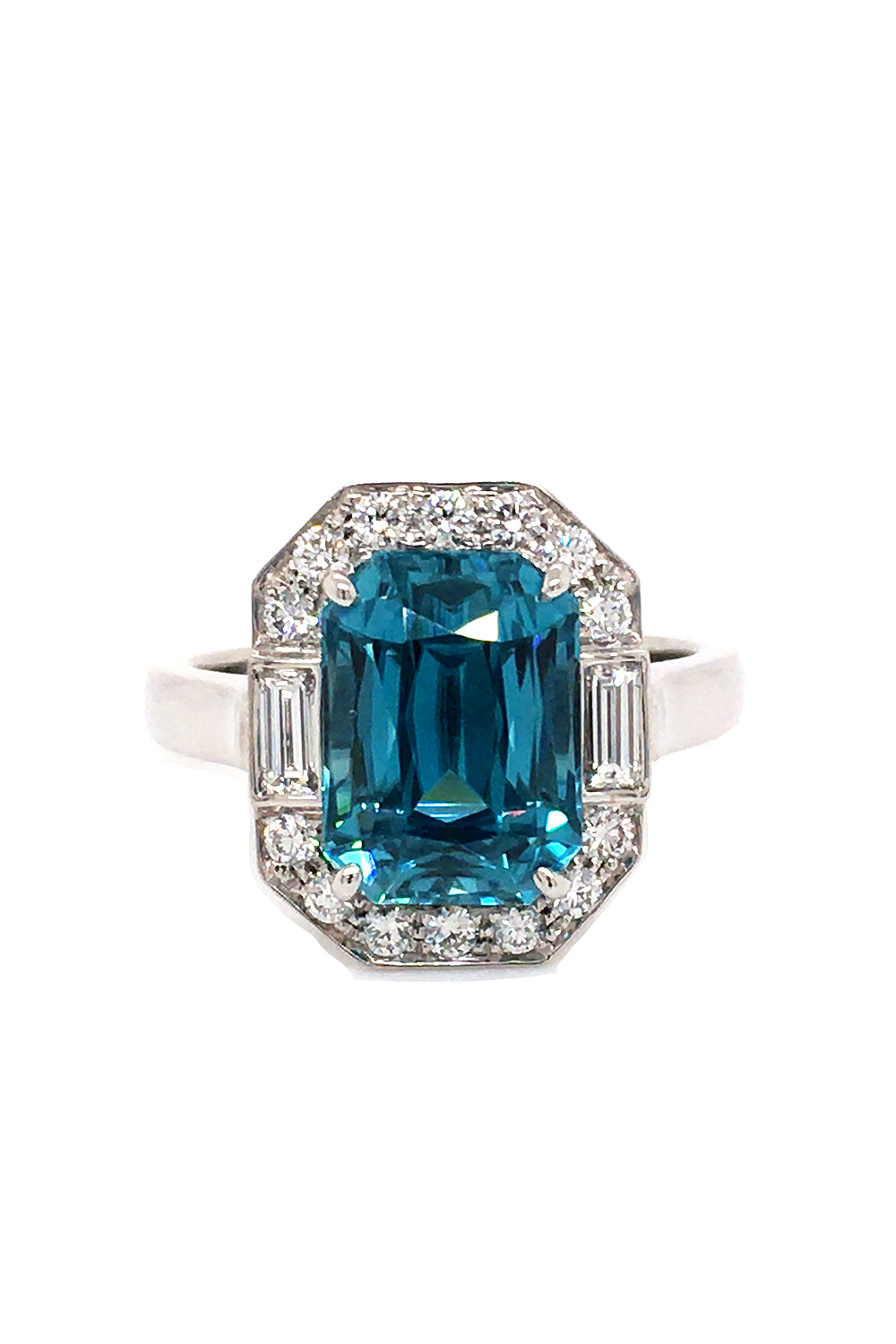 18K white gold ring with an emerald-cut blue zircon and baguette and brilliant  diamonds on a white background