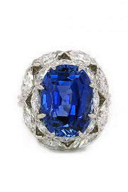 Sapphire surrounded by marquise diamonds in a platinum ring on white background
