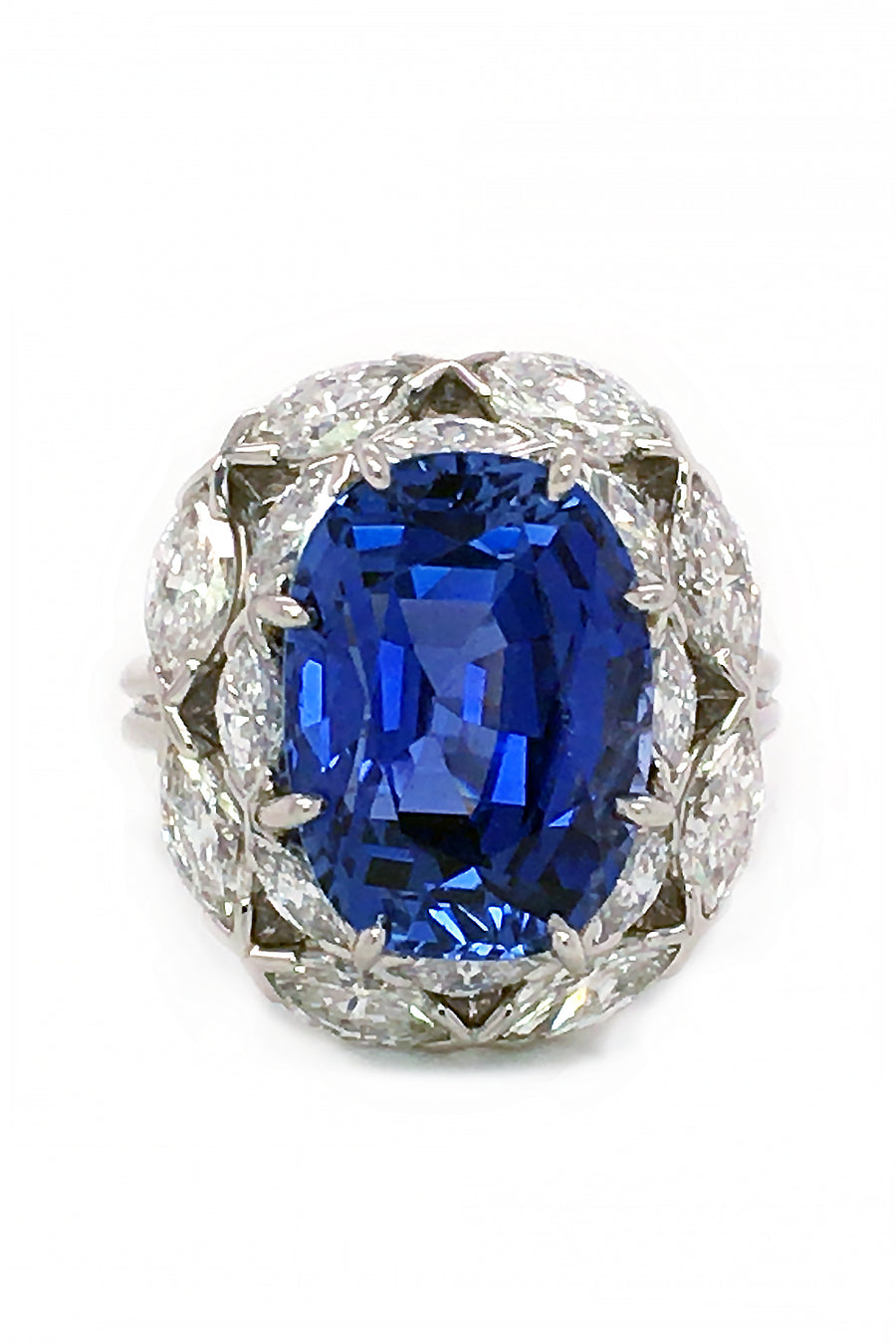 Sapphire surrounded by marquise diamonds in a platinum ring on white background