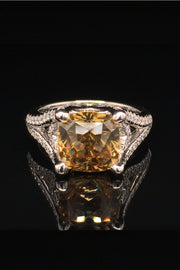 18K white gold ring with a golden zircon and diamonds on a black background.