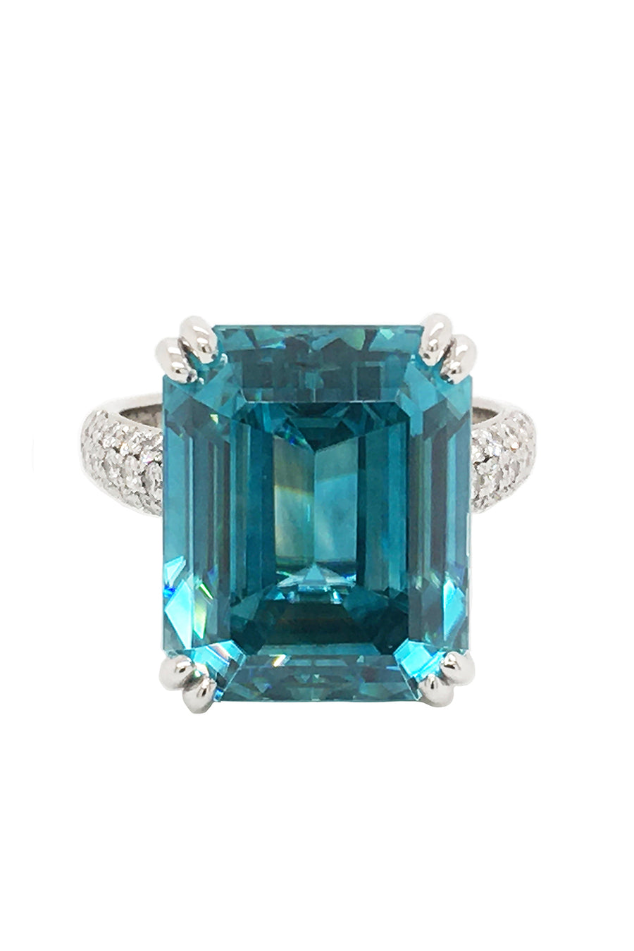 Platinum ring with emerald-cut blue zircon and round diamonds on white background.