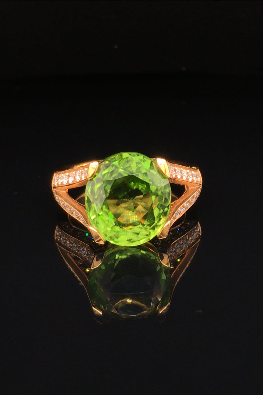 20K pink gold peridot ring with diamonds on black background.