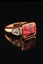 20K pink gold ring with a rubellite and diamonds on black background.