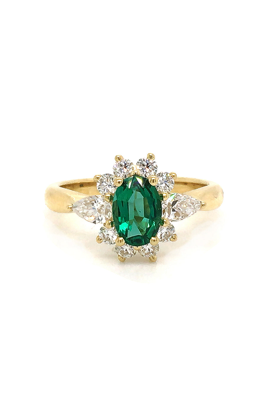 18K gold ring featuring an oval emerald with diamonds on a white background