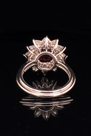 Back view of platinum ring featuring a ruby surrounded by pear shape diamonds black background.