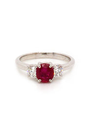 18K white gold ring featuring a ruby and two round diamonds on white background