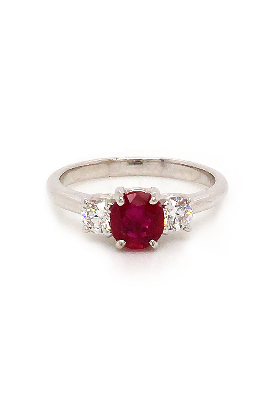 18K white gold ring featuring a ruby and two round diamonds on white background