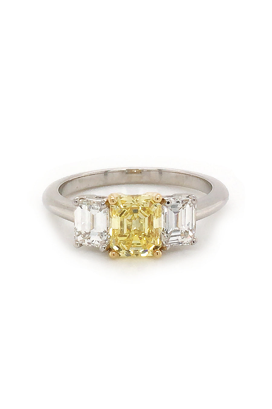 Ring with canary diamond with 18K yellow gold prongs and diamonds set in a platinum on white background