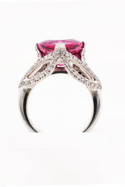 Side view of 18K white gold ring featuring a large trilliant cut rubellite with diamonds on a white background