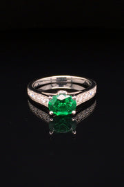 Platinum ring  with oval emerald and diamonds on black background