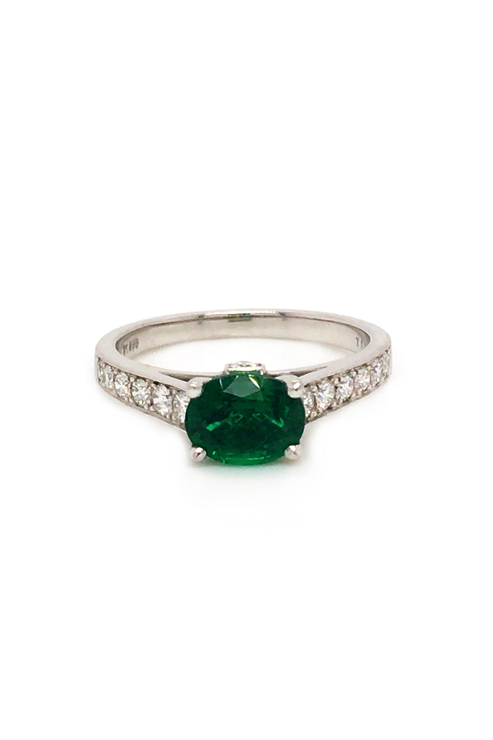 Platinum ring  with oval emerald and diamonds on white background