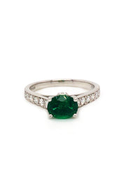 Platinum ring  with oval emerald and diamonds on white background