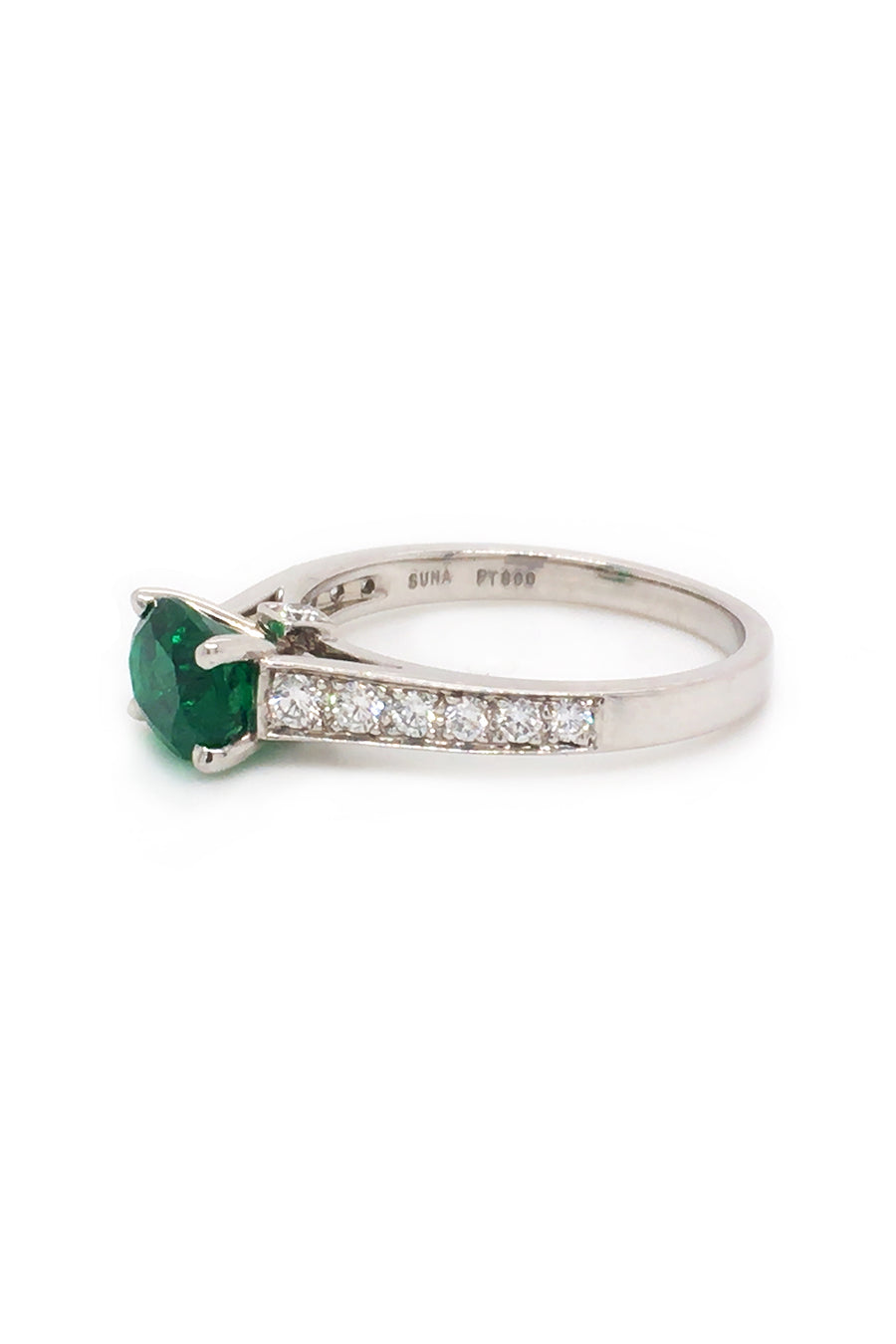 Angle view of platinum ring  with oval emerald and diamonds on white background