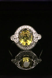 18K white gold ring with a yellow sapphire and lace motif with diamonds on a black background