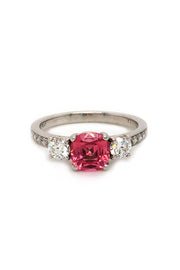 Platinum ring with pink-orange spinel and diamonds on white background