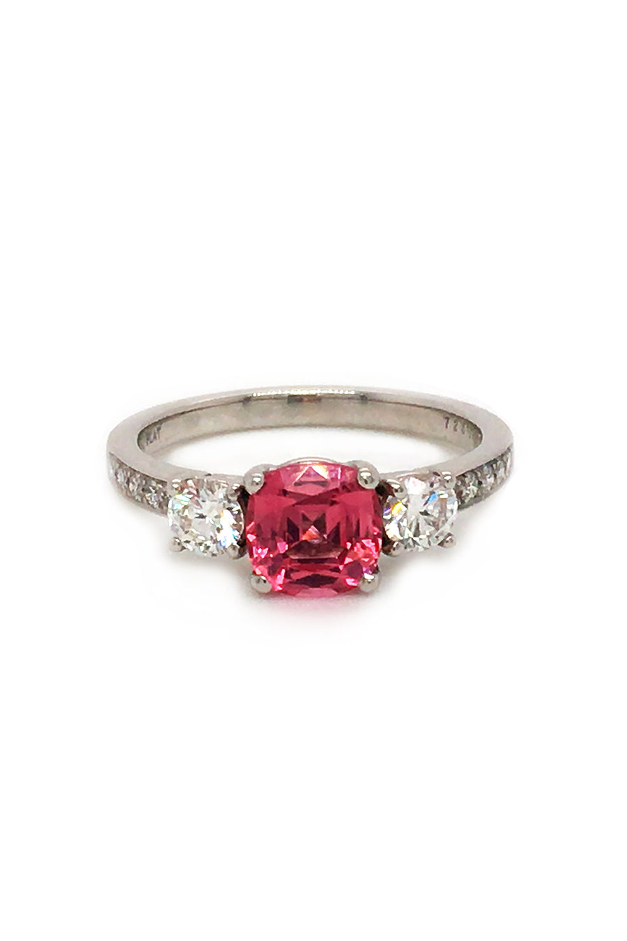 Platinum ring with pink-orange spinel and diamonds on white background