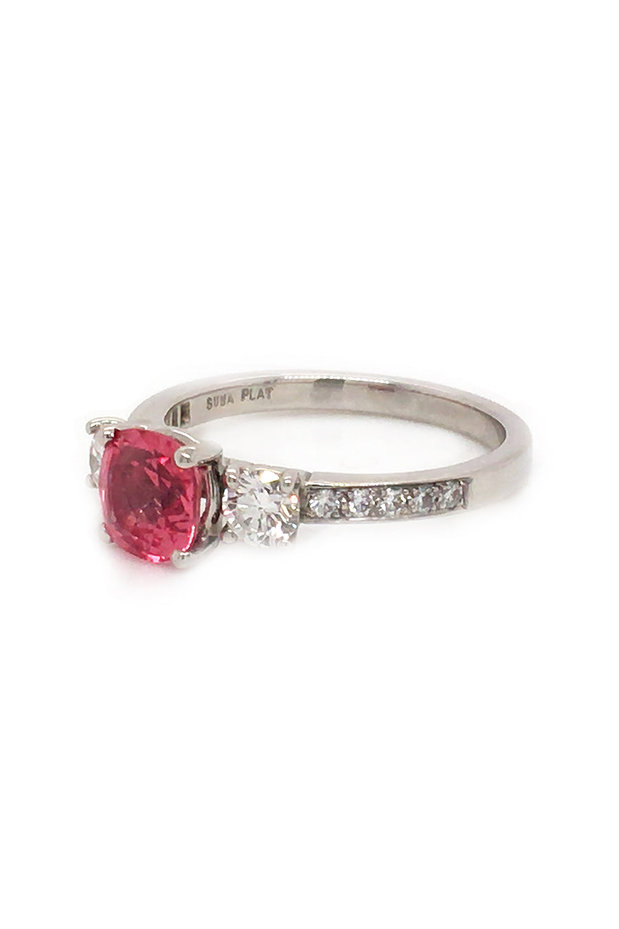 Angle view of platinum ring with pink-orange spinel and diamonds on white background