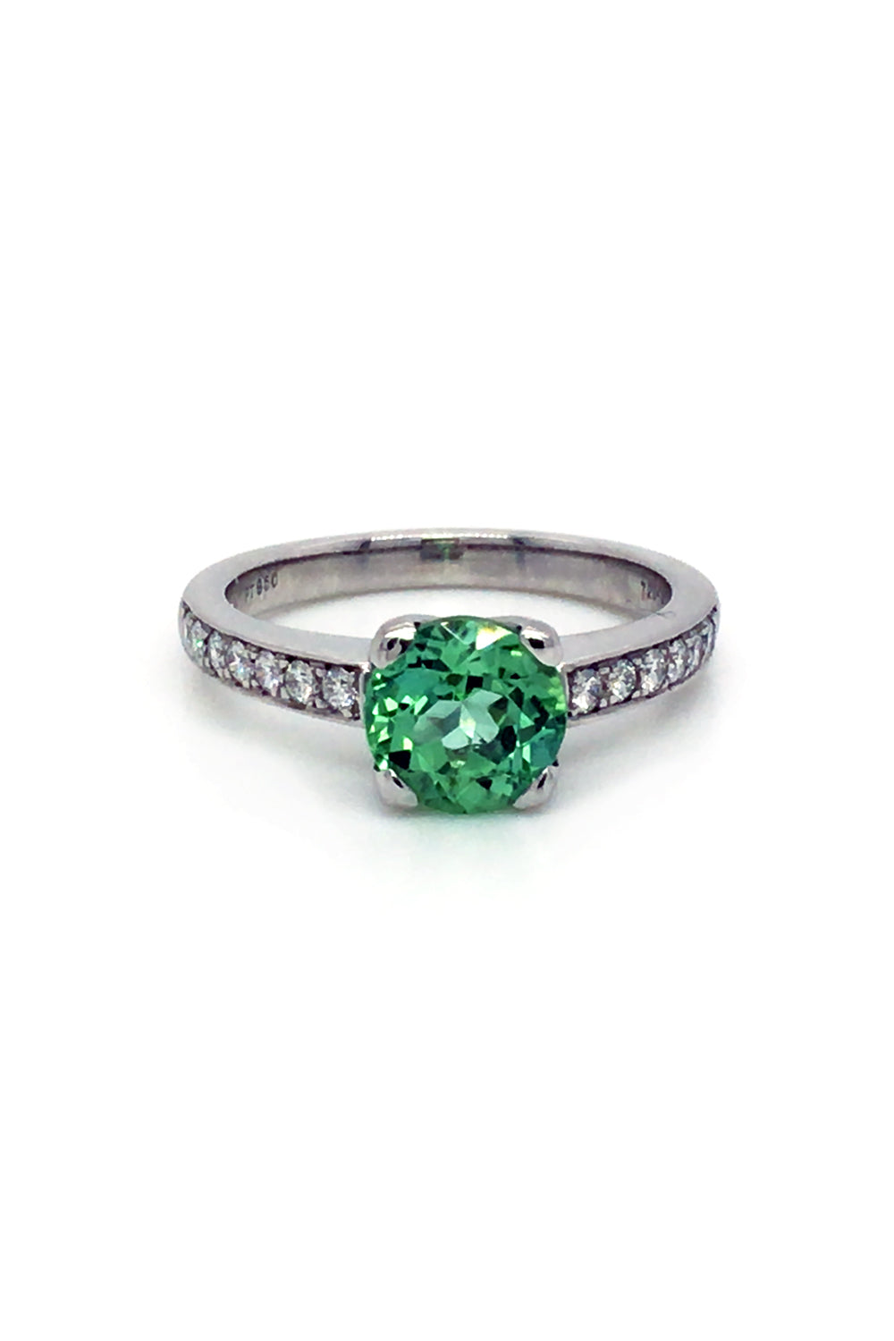 Round mint green tourmaline set in a platinum ring with diamonds on white background