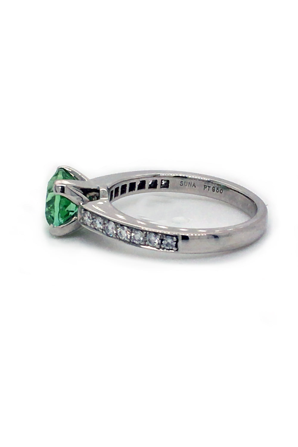Side view of round mint green tourmaline set in a platinum ring with diamonds on white background