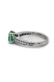 Side view of round mint green tourmaline set in a platinum ring with diamonds on white background