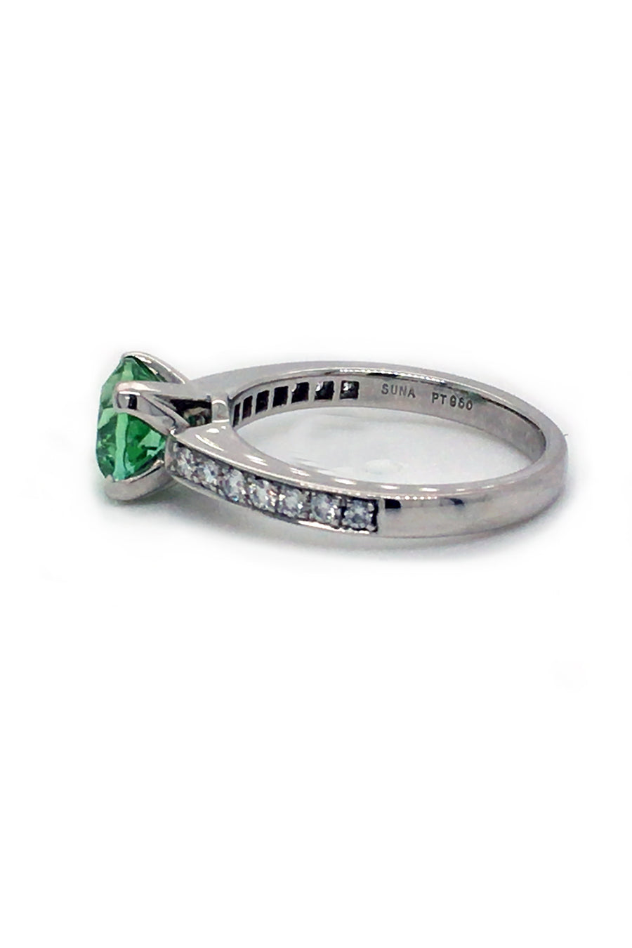 Side view of round mint green tourmaline set in a platinum ring with diamonds on white background