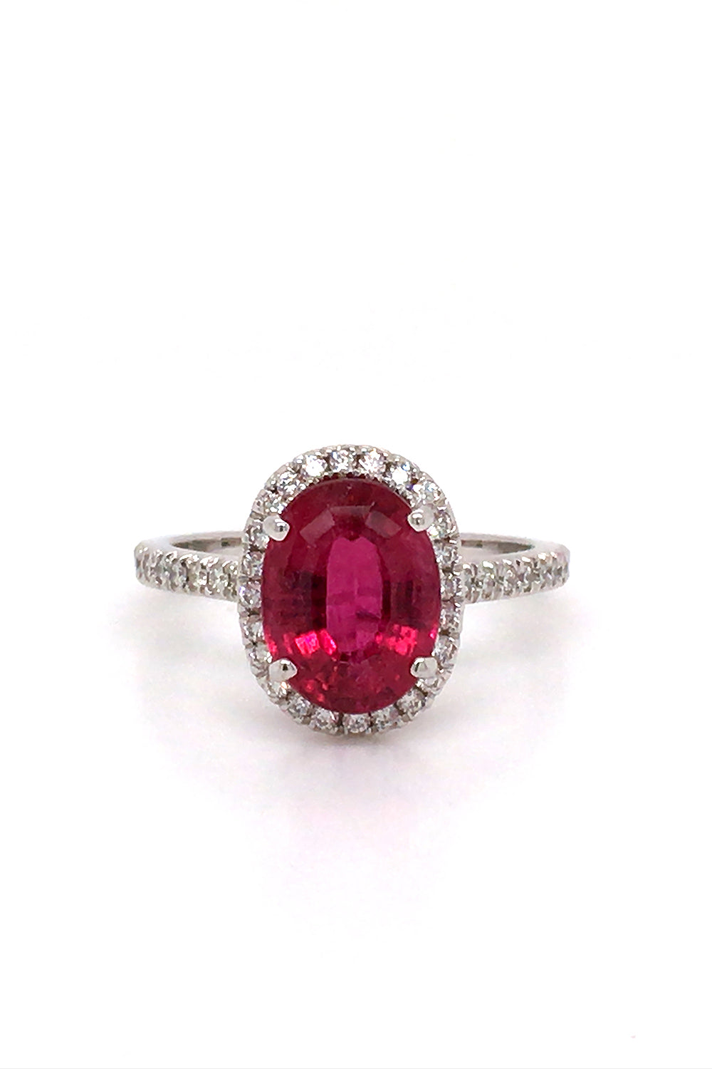 18K white gold ring with an oval rubellite with a diamond halo on a white background