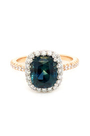 20K pink gold ring with a cushion-cut teal sapphire and diamond halo on a white background.