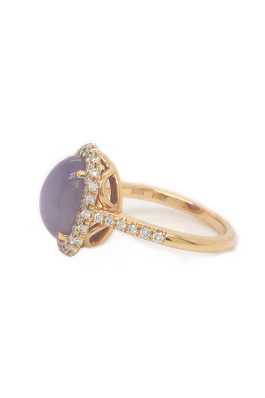Side view of lavender star sapphire ring with a diamond halo in 20K pink gold on a white background.