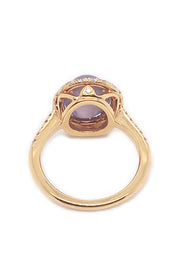 Back view of lavender star sapphire ring with a diamond halo in 20K pink gold on a white background.