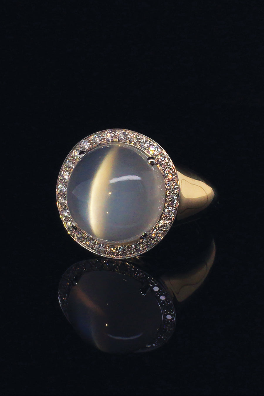 18K white gold ring with cat's eye moonstone gemstone and diamonds on black background