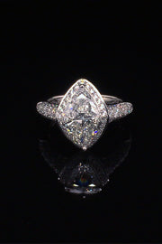 Platinum ring with two trilliants surrounded by pavé diamonds on a black background.