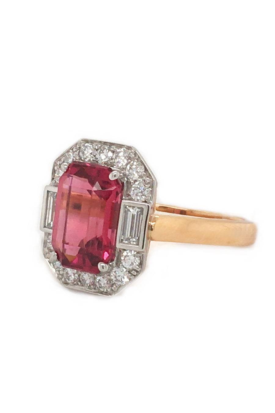 Angle view of rubellite set in platinum with diamonds on 20K pink gold ring on white background.