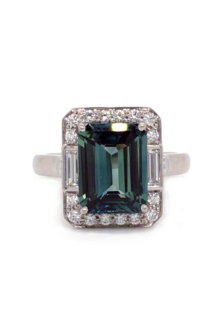 Emerald-cut green sapphire with baguettes and brilliant diamonds in platinum on a white background