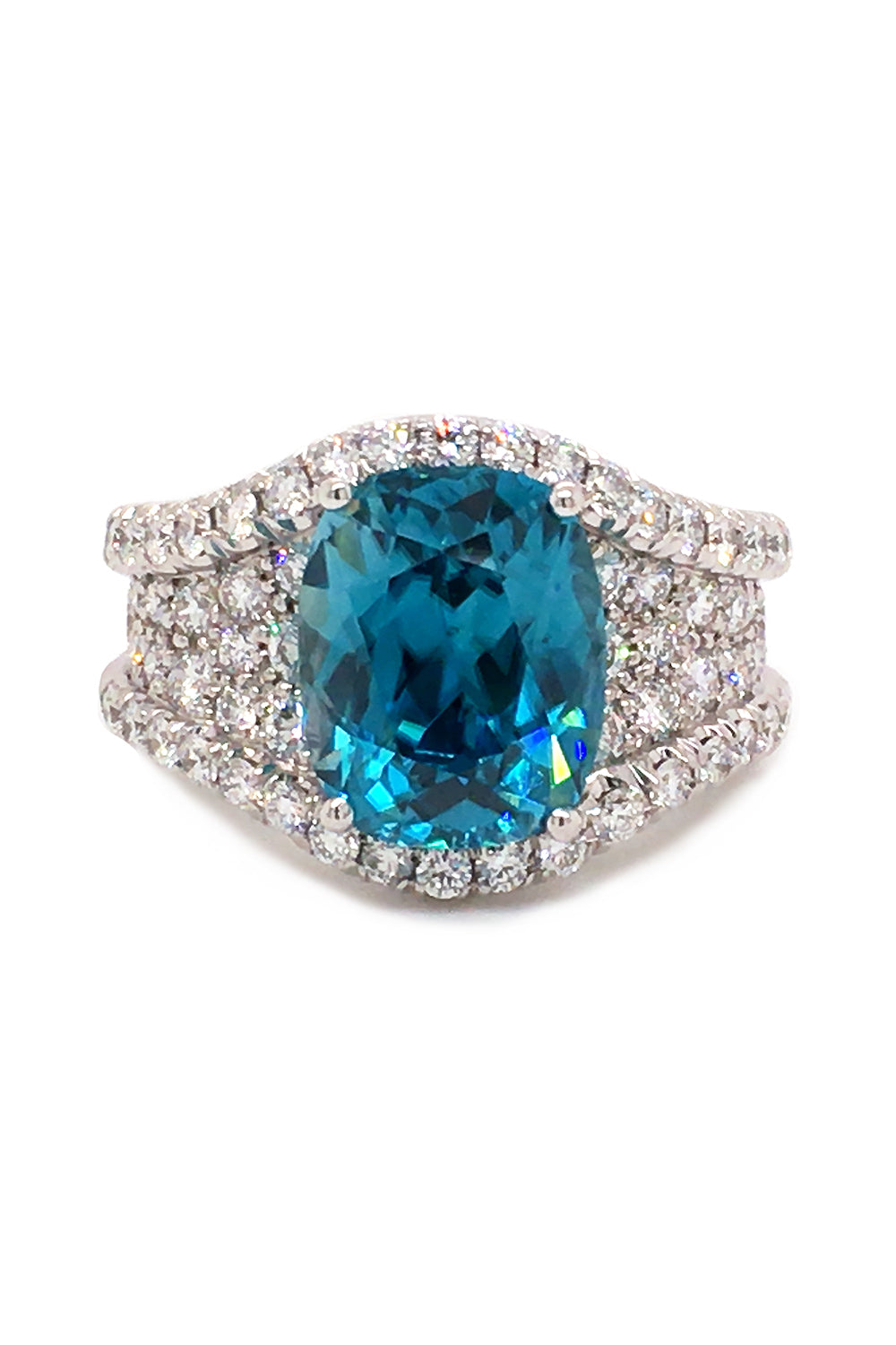 Platinum ring with a blue zircon, sapphire accents, and diamonds on a white background