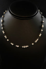 Platinum wire necklace with diamonds on a black necklace display