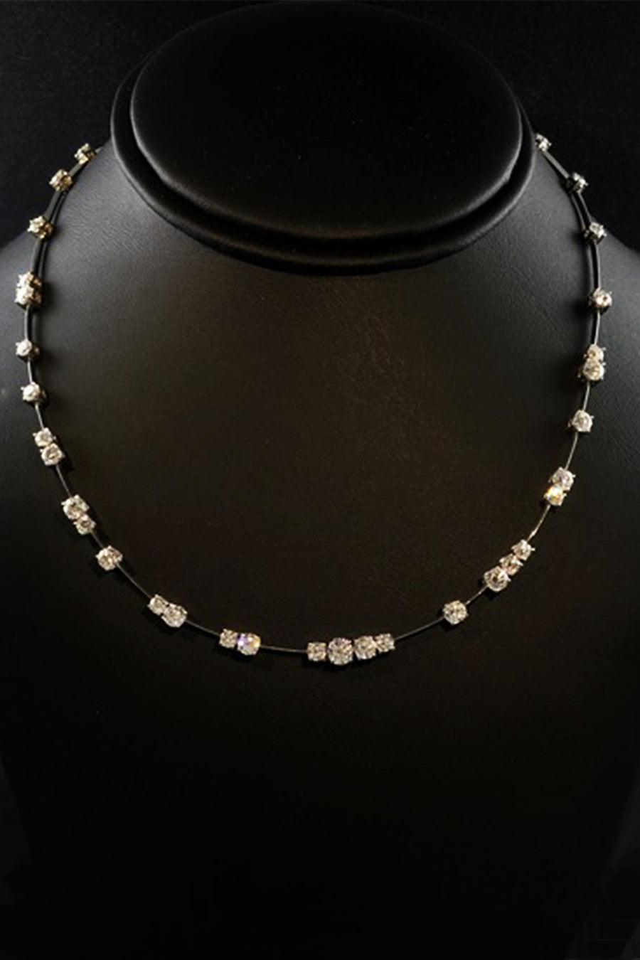 Platinum wire necklace with diamonds on a black necklace display