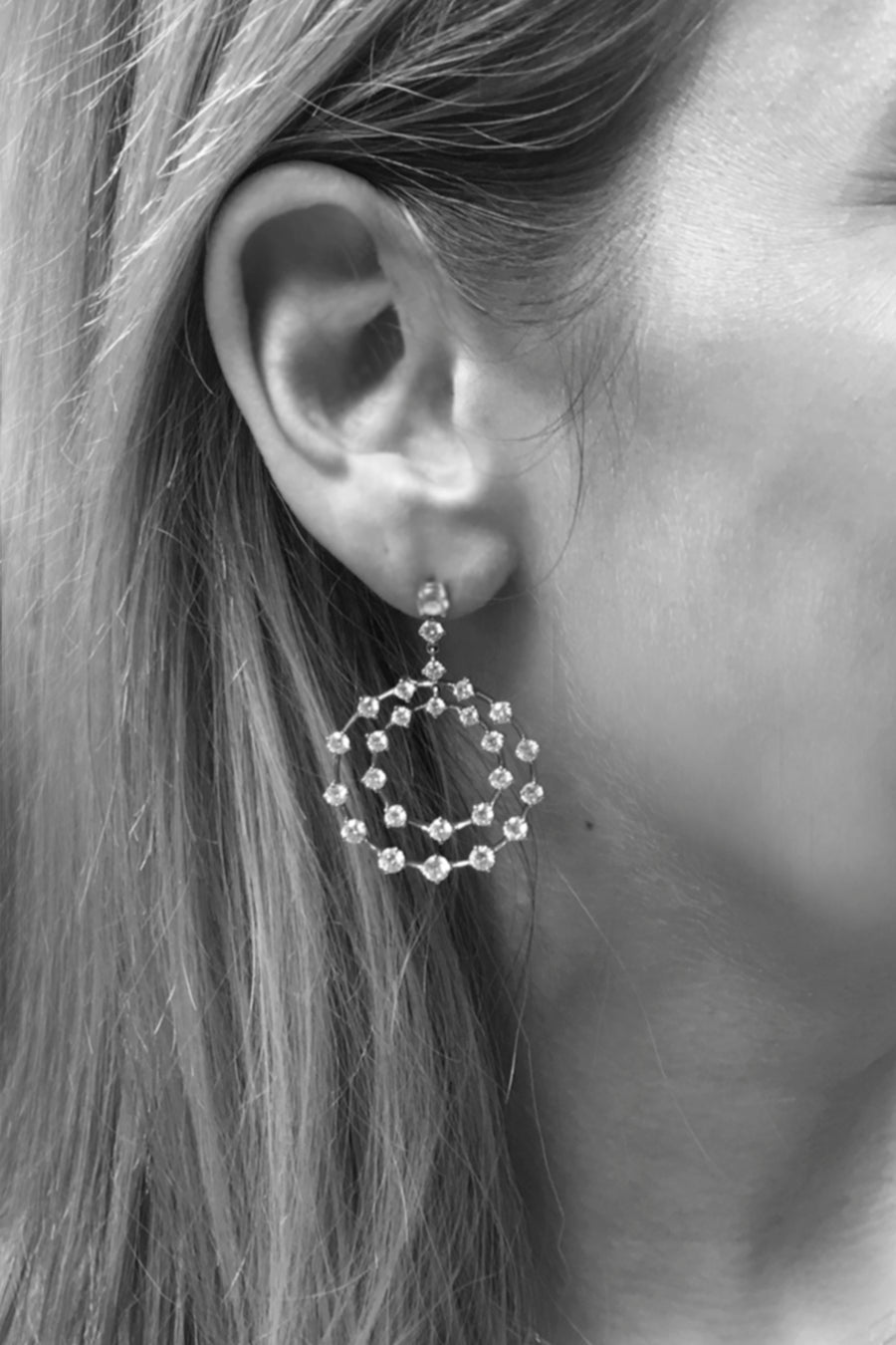 Closeup of woman's ear wearing diamond double circle earrings