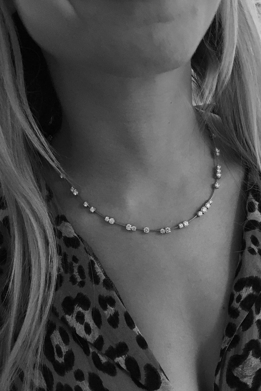 Closeup of woman's neck wearing diamond necklace