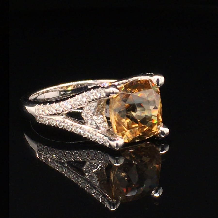 Angle view of 18K white gold ring with a golden zircon and diamonds on a black background.