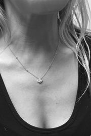 Closeup of woman's neck wearing petite lace pendant